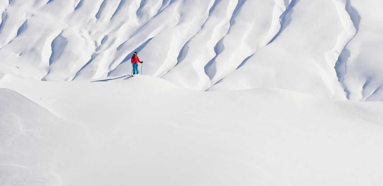 vue-de-haut-d-un-skieur-seul-dans-la-poudreuse-en-train-de-faire-des-virages-a-flanc-de-montagne-dans-les-alpes-autrichiennes