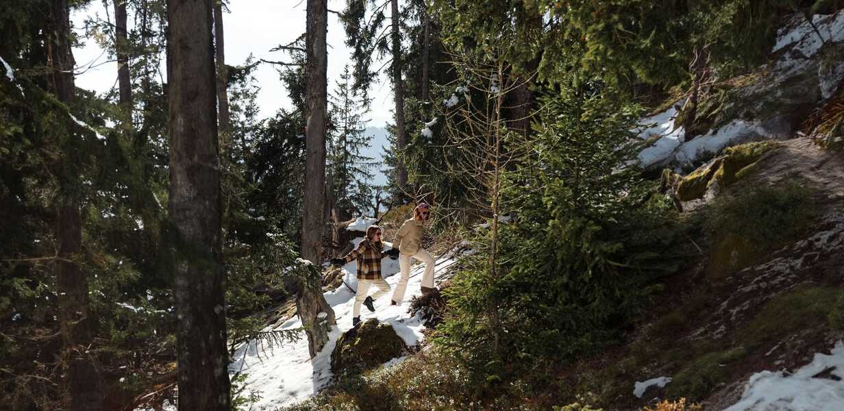 two-young-girls-walking-laughing-in-the-forest-meribel