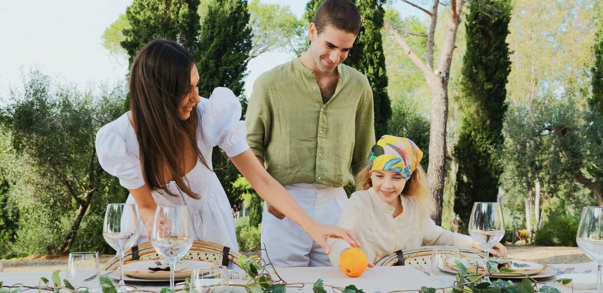 parents-avec-leur-petite-fille-dressant-la-table-dehors-campagne-italienne