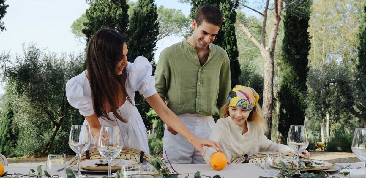 famille-mettant-la-table-a-l-exterieur-dans-une-villa-de-luxe-en-italie