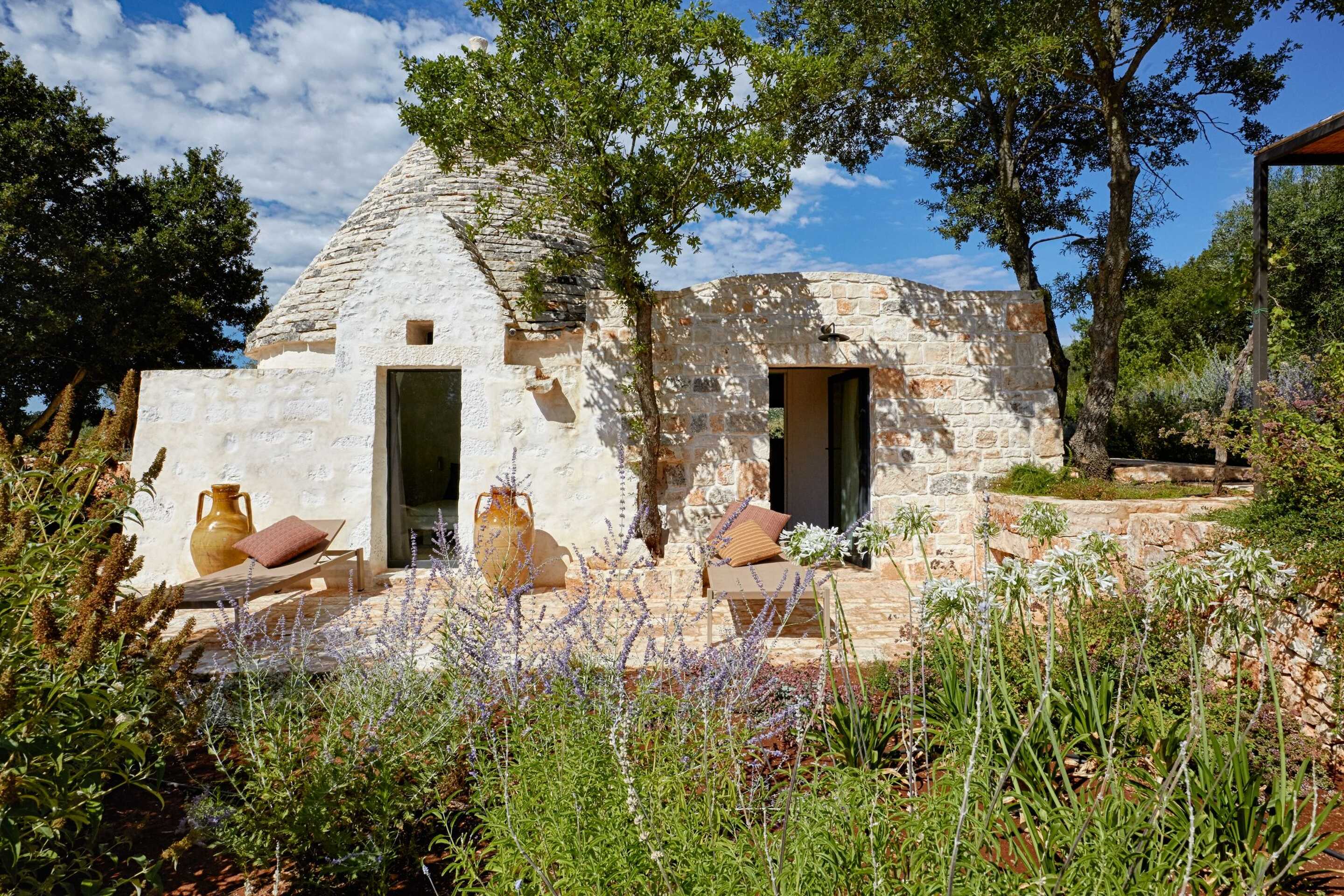 facade-blanchie-a-la-chaux-d-une-trulli-traditionnelle-avec-jardin-villa-luxe-italie
